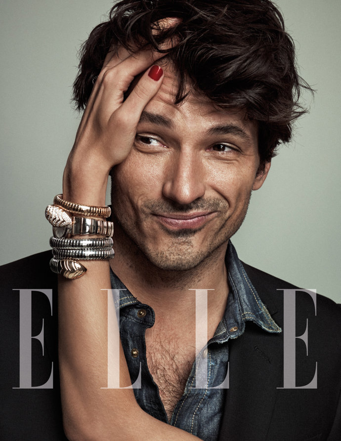 Andrés Velencoso en un primer plano, muy guapo y divertido, con gesto pícaro porque la mano de un mujer le toca el pelo