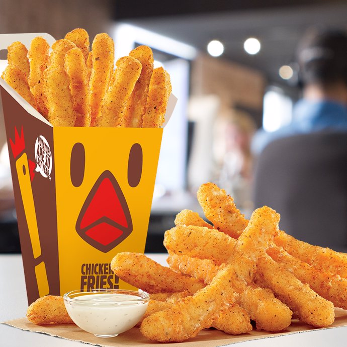 Caja de Chicken Fries con los snacks de pollo rebozado en un plato que parecen patatas fritas con salsa ali oli