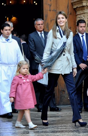 2010 fue uno de los años más lluviosos durante esa época estival. Letizia lució un mix, de los años anteriores. Gabardina en color gris, anudada, pantalones rectos azul marino, y unos letizios de ante la mar de discretos en oscuro. El día lo requería y adornó su atuendo con una foulard a rayas en los mismos tonos.