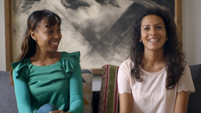 Dos mujeres sentadas hablando y riéndose al descubrir que son guapas sin estar dentro de los estereotipos y dictámines de la moda y la belleza. Son guapas, naturales sin maquilajes artificiales