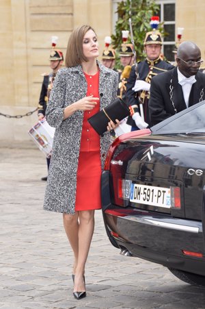 Para su encuentro con el primer ministro, Valls, Letizia se pasó a Nina Ricci con vestido rojo combinado con un abrigo tweed en negro y blanco.