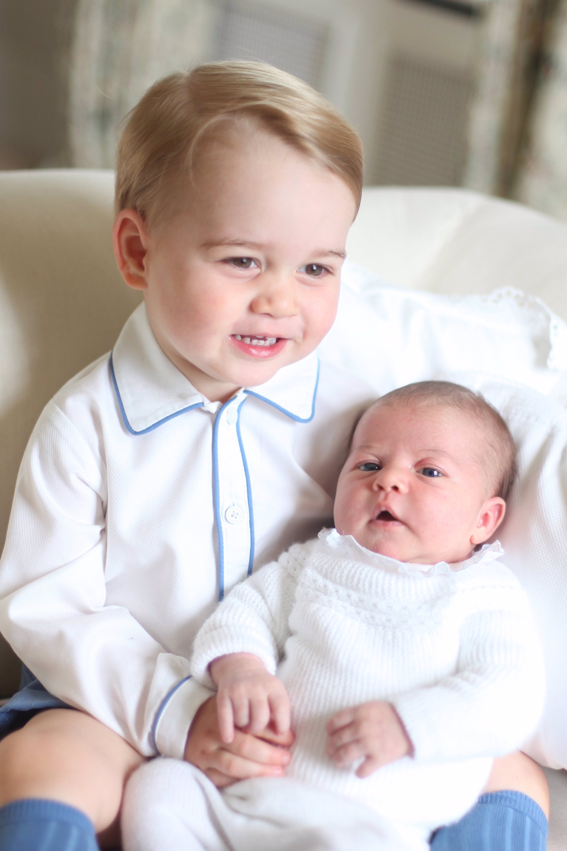 El Príncipe George con su hermana la Princesa Charlotte en brazos