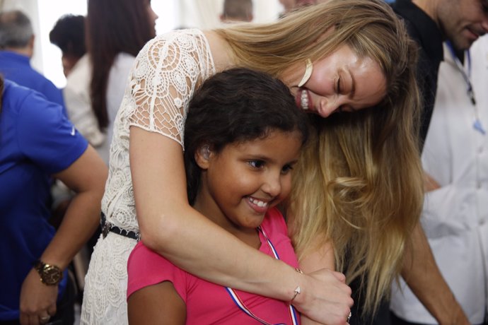 Amber Heard con una de las niñas que recibió un audífono