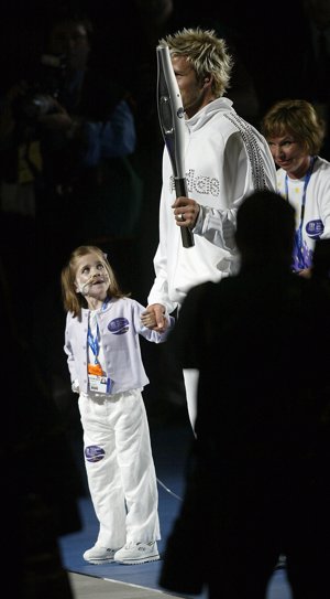 David Beckham portando la llama olímpica de en los Juegos de la Commonwealth junto a Kirsty Howard