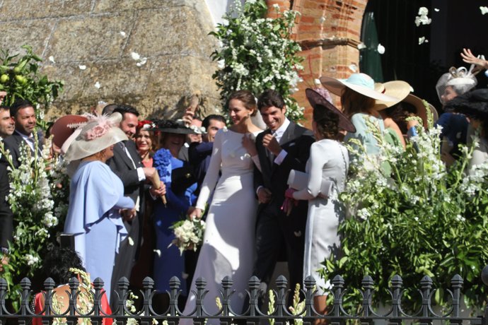 los novios salen conviertidos en marido y mujer bajo una lluvia de pétalos de rosa