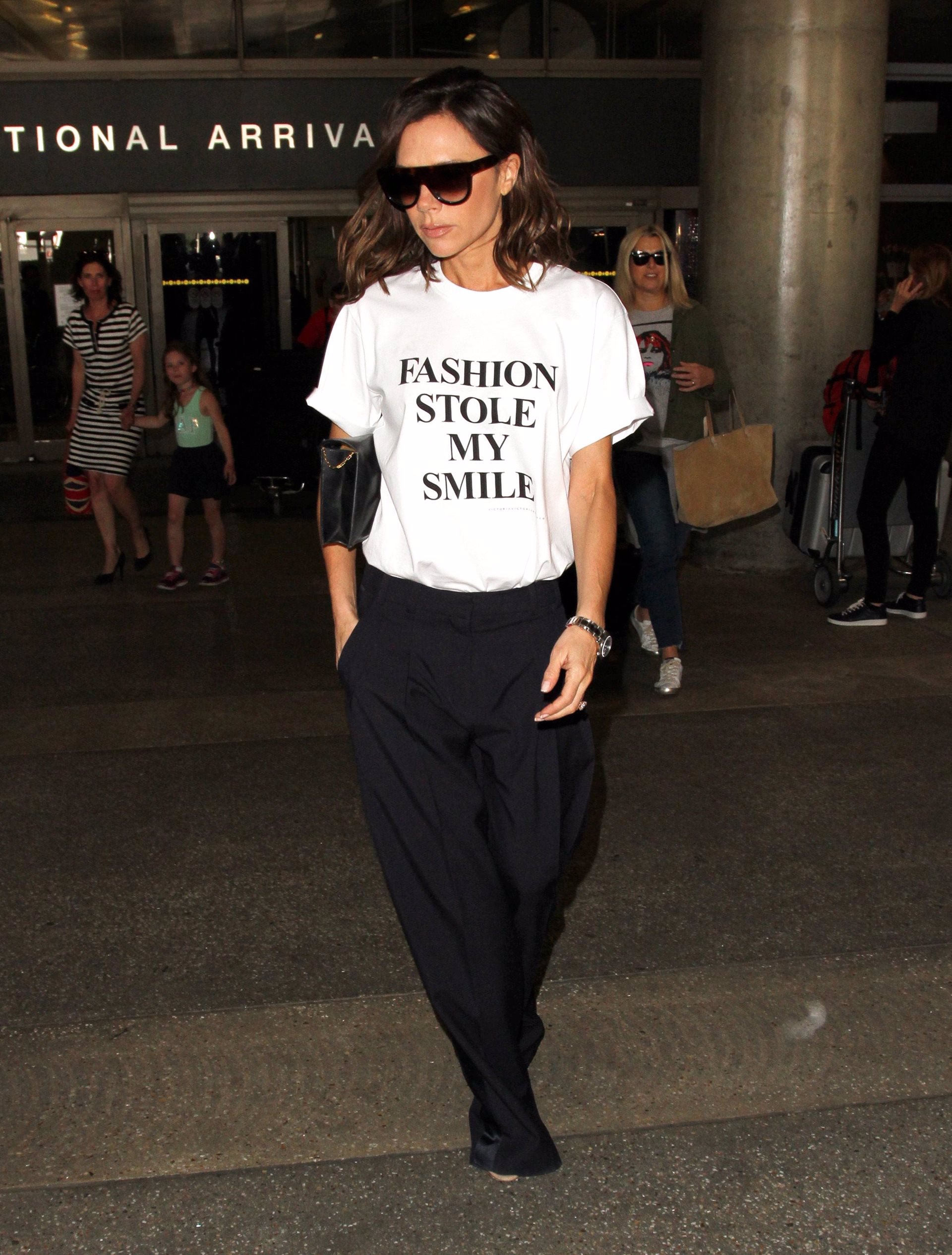 Victoria Beckham elige su look low cost de camiseta básica blanca con letrero de Smile y pantalón negro que ha creado:VBxTarget