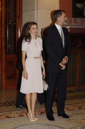 Un vestido rosa nude con falda plisada, corte vertical en el escote y manga corta de Hugo Boss