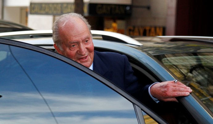 rey juan carlos come en el paraguas y entra en coche