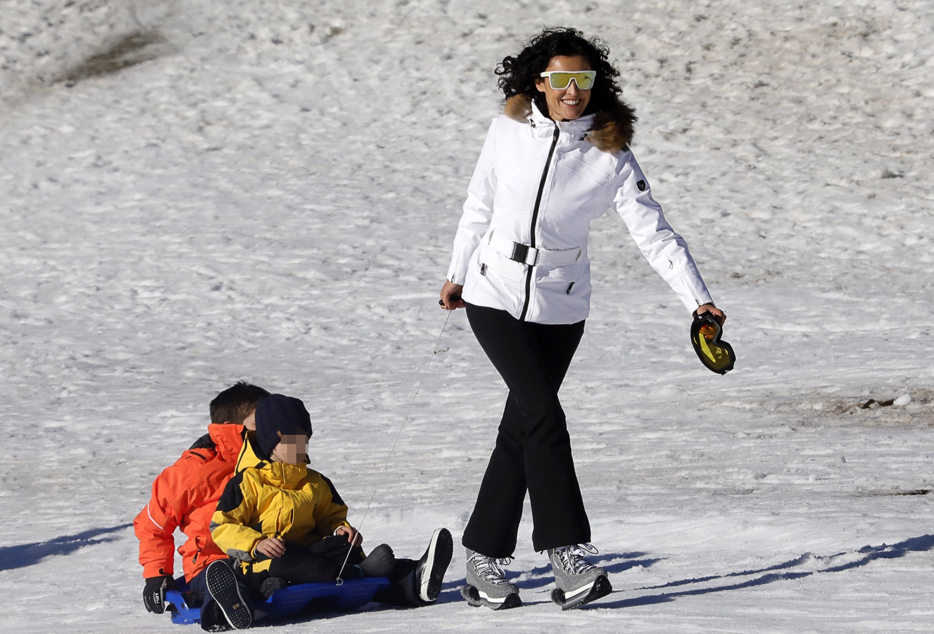 blanca romero disfruta de su hijo Martín en la nieve tirando de un trineo con otro niño