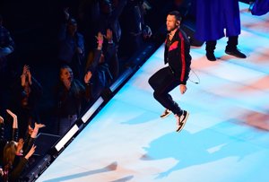 Adam Levine, ya sin abrigo y solo con cazadora ya saltando durante el medio tiempo de la final de la  Super Bowl