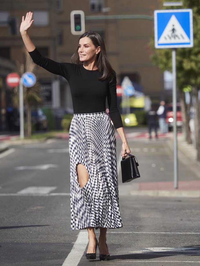 La Reina, con una falda con un enorme agujero a la altura de la rodilla