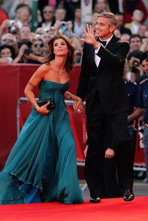 Orgulloso de su pareja y de la mano, George saluda