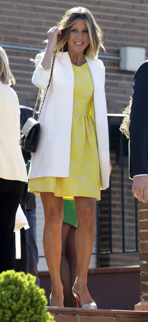 Natalia Álvarez con un vestido corto amarillo y una gabardina blanca