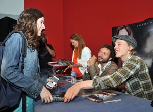 Jamie Campbell Bower firma autógrafos del libro Cazadores de Sombras a los fans allí reunidos