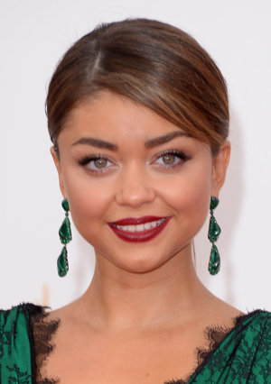 Sarah Hyland recogió su pelo en un moño bajo con raya lateral.