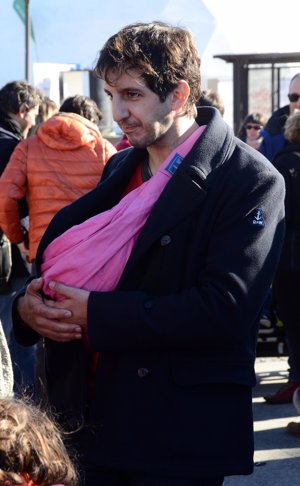 El actor Guillermo Ortega protege a su bebé en el fular canguro, sujetando con las dos manos para que no esté muy tirante