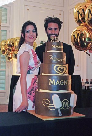 Adriana Ugarte y el diseñador Juan Vidal junto a la tarta que conmemora los 25 años del rey del helado: Magnum