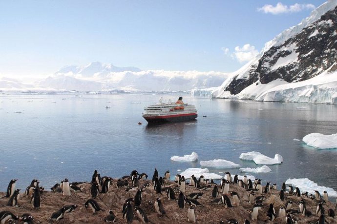Barcos y pingüinos en la Antártida.
