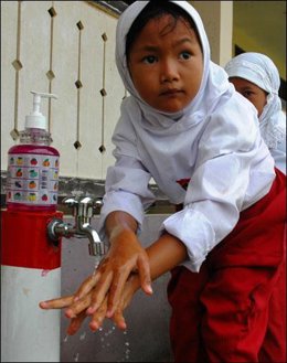 Una muchacha en Kahju, Aceh Besar está practicando como lavarse las manos correc