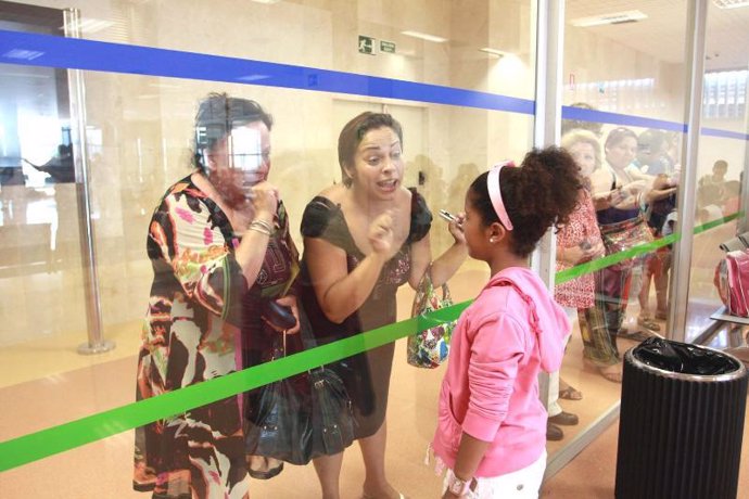 Una niña saharaui se despide de su familia de acogida en el aeropuerto de Málaga