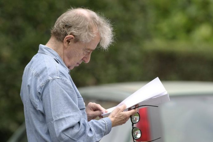 Allen consulta sus papeles en Oviedo.