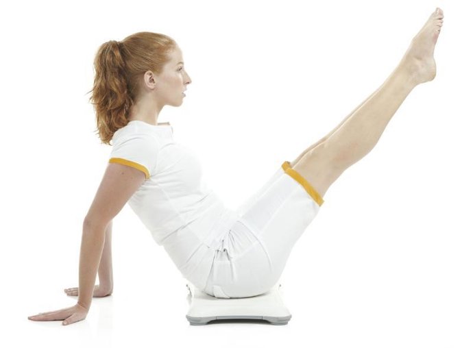 Una mujer hace ejercicio con la Balance Board y Wii Fit Plus