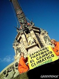 'Greenpeace' escala, por el clima, la estatua de Colón en Barcelona 