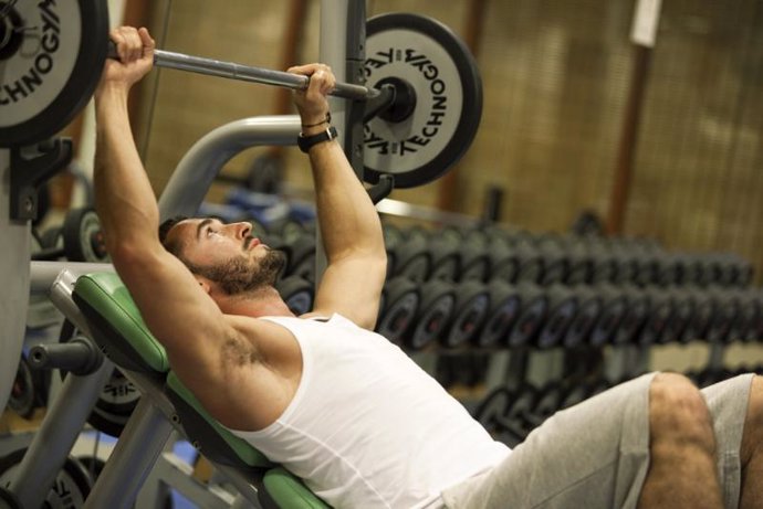 Hombre levantando pesas ejercicio deporte gimnasio