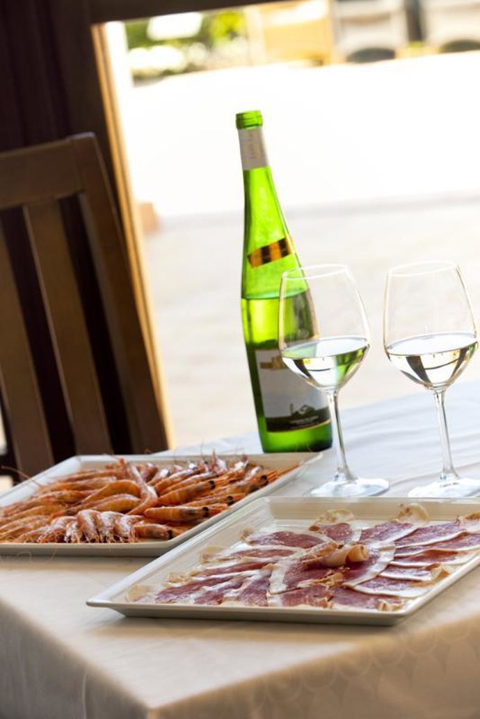 Mesa comida cena langostinos jamón vino 