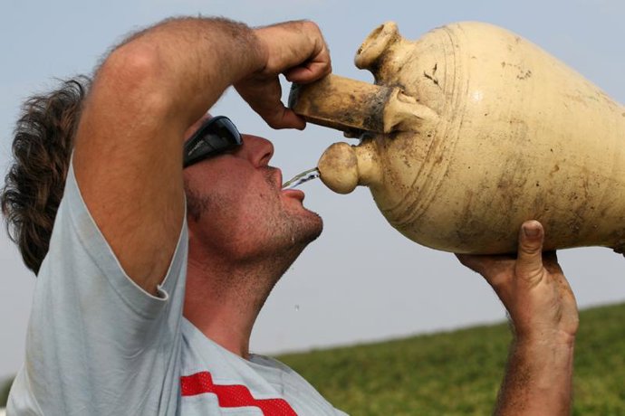 Hombre bebe agua por el calor