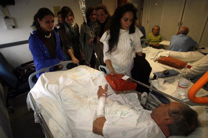 Una voluntaria de la UPO entrega regalos en el Hospital