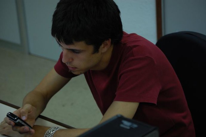 Usuario mandando un SMS con su teléfono móvil