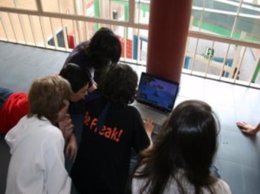 Adolescentes con un portátil en los pasillos del instituto
