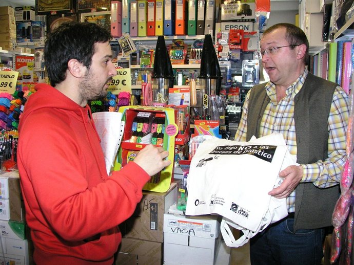 Un Vendedor De Un Comercio De La UPO Conversa Con Un Estudiante Sobre Las Bolsas