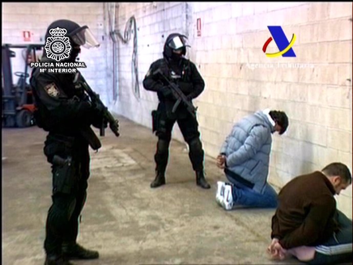 La Policía Custodia A Dos Detenidos En La Operación.
