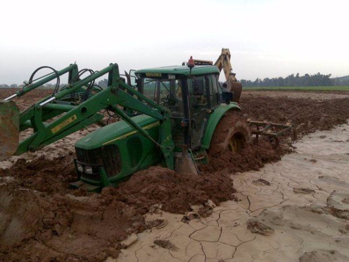 Un Tractor En Una Parcela Que Sufrió Inundaciones Y En La Que Aún Quedan Lodos Q