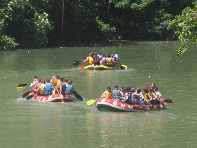 Alumnos navarros bajan en balsas por el río Arga.