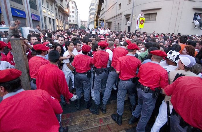 Agentes de la Policía Foral contienen al público antes de un encierro.