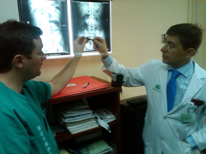 Médicos sosteniendo un iman ingerido por un niño y radiografías