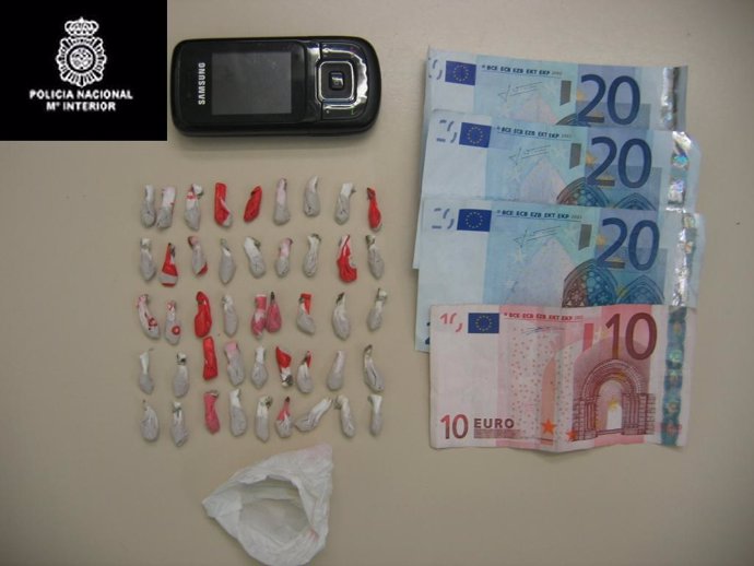 Las dosis de heroína incautadas, junto al dinero y el móvil. 