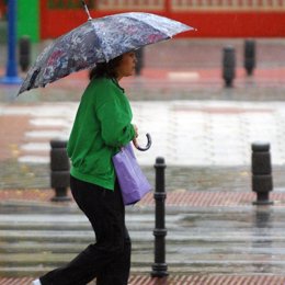 mujer paraguas lluvia cruza calle recursos