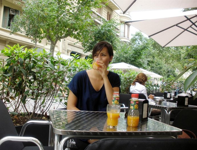 Una mujer se refresca con un zumo