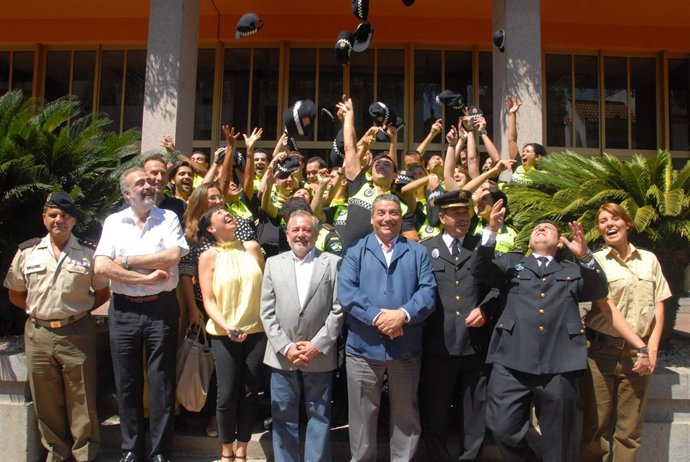 Los agentes, junto al alcalde, celebran su graduación lanzando sus gorras al air