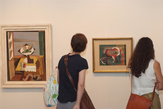 Dos jóvenes observan algunas de las obras de Joaquín Peinado en el Museo Provinc