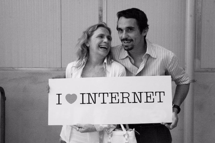 Una pareja posa con un cartel que dice "I love Internet".