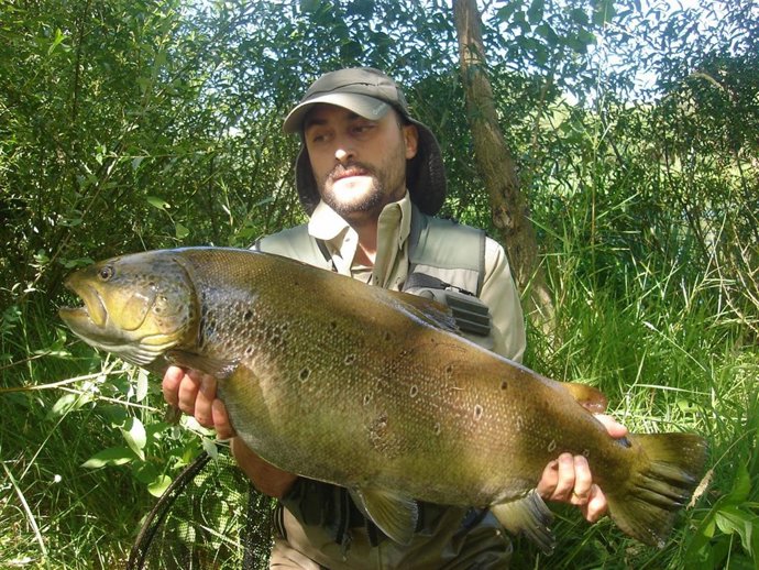 Paco García muestra la trucha capturada