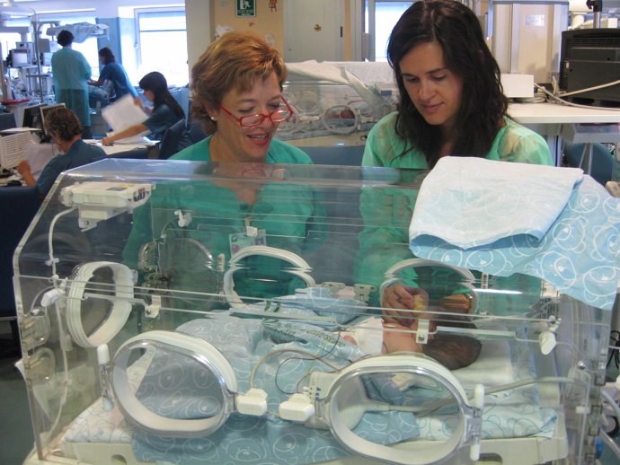 Enfermeras asisten a un neonato en una incubadora