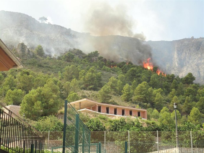 Residencia de Simat con el incendio al fondo