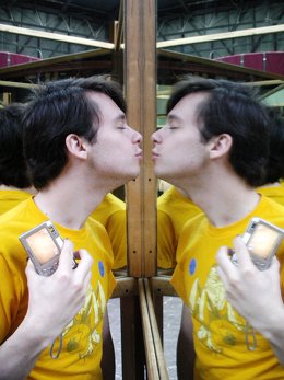 Un hombre se da un beso a sí mismo en el espejo.