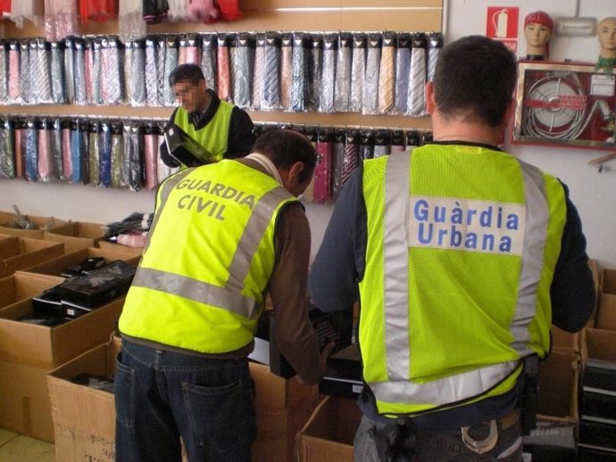 Agentes de la Guardia Urbana y de la Guardia Civil en el decomiso de material fa